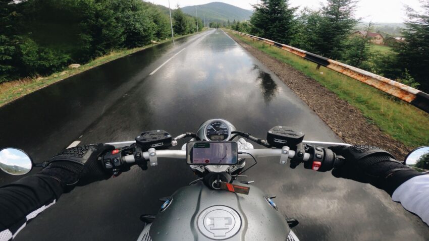 雨で濡れた道を走るバイク