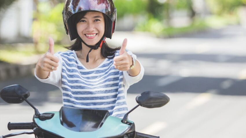 笑顔でバイクに乗る女性