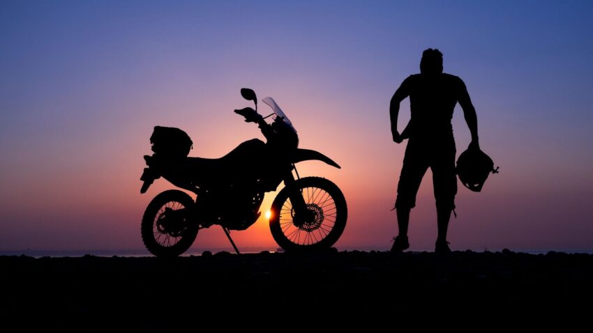 夕焼けとバイクと人のシルエット