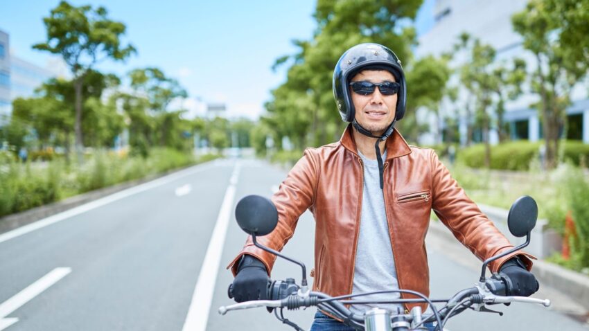 サングラスをかけてバイク雨に乗る人