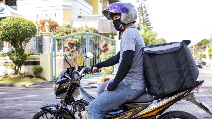バイクに跨ってリュックやシートバッグを使う人