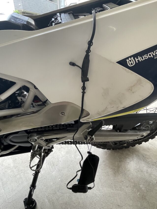 モバイルバッテリーをバイクのステップにかけている