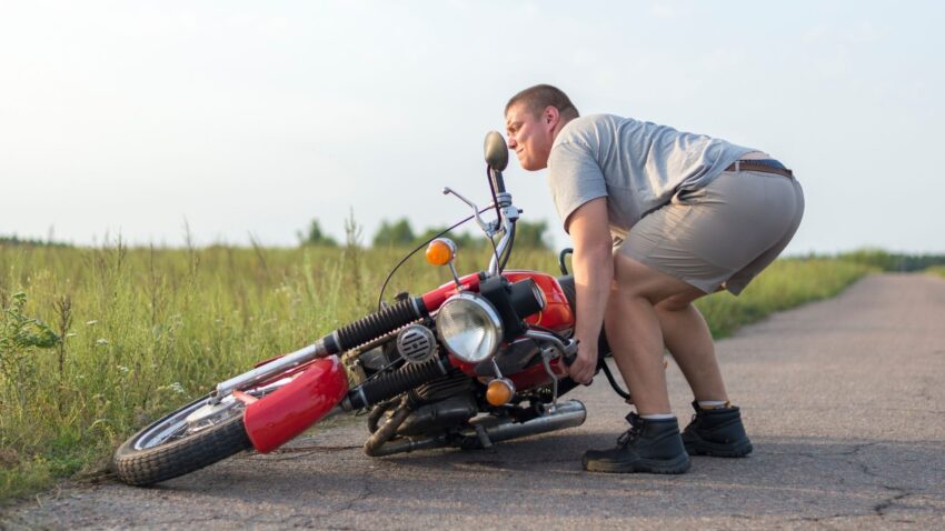 こけたバイクを引き起こす人