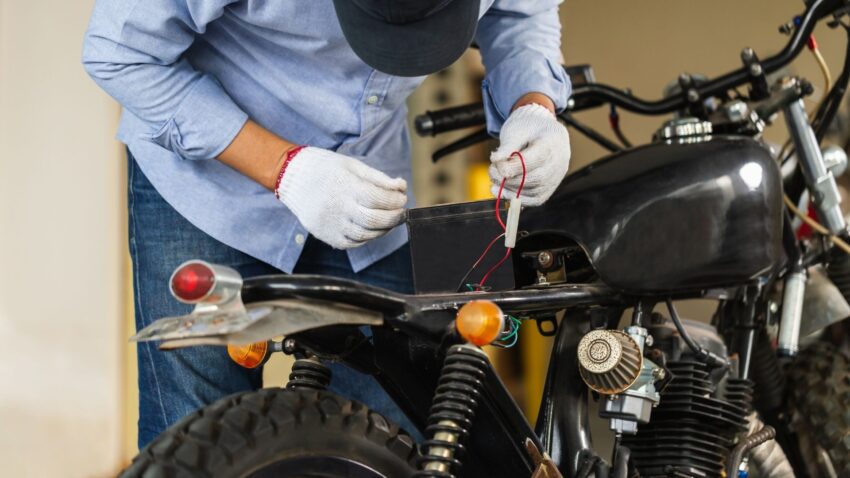 バイクのバッテリーを取り外す人